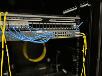 Blue and yellow network cables in server rack.